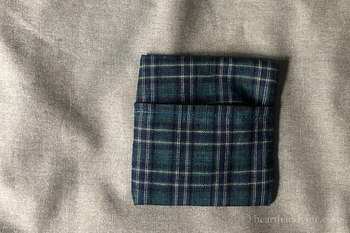 Blue and green plaid fabric turned right side out making an envelope pocket.