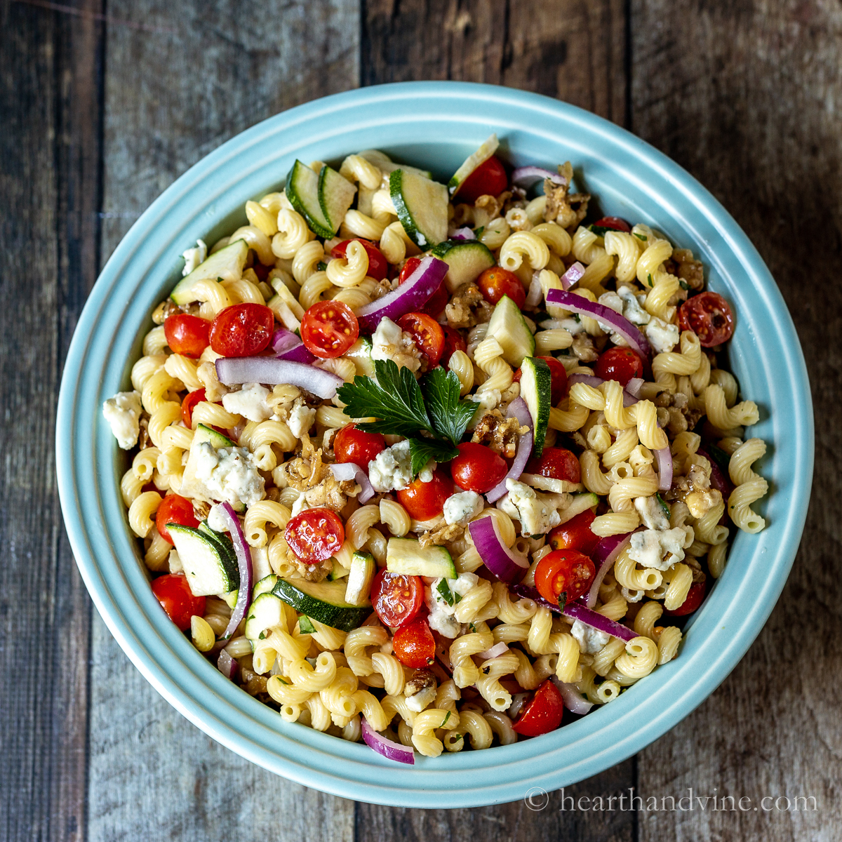 Blue cheese pasta salad in a large blue serving bowl.