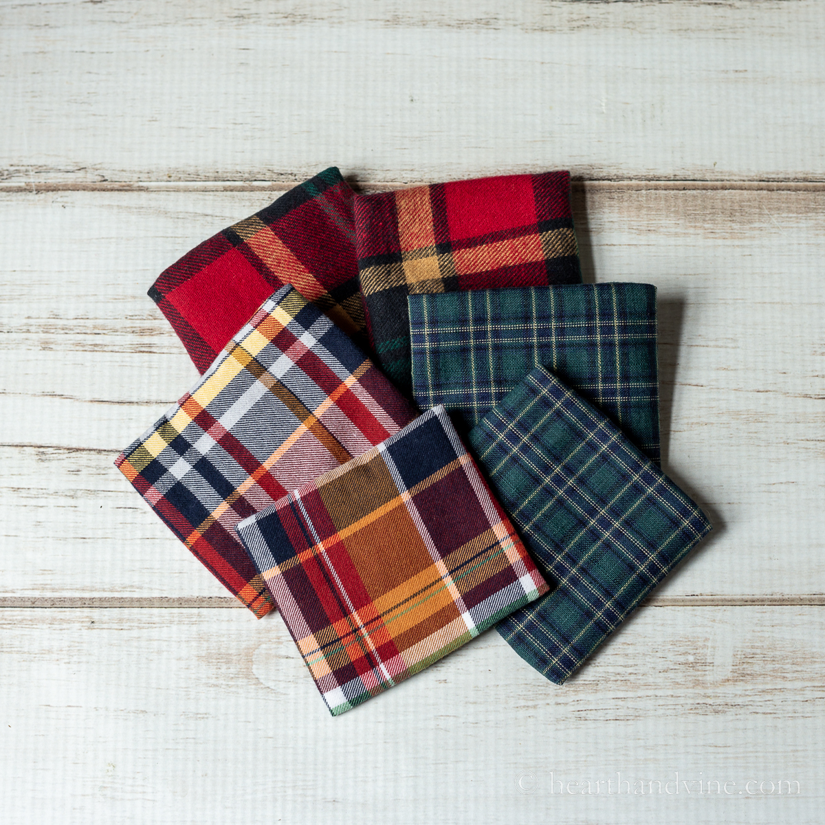 Three sets of hand warmers in plaid fabric.