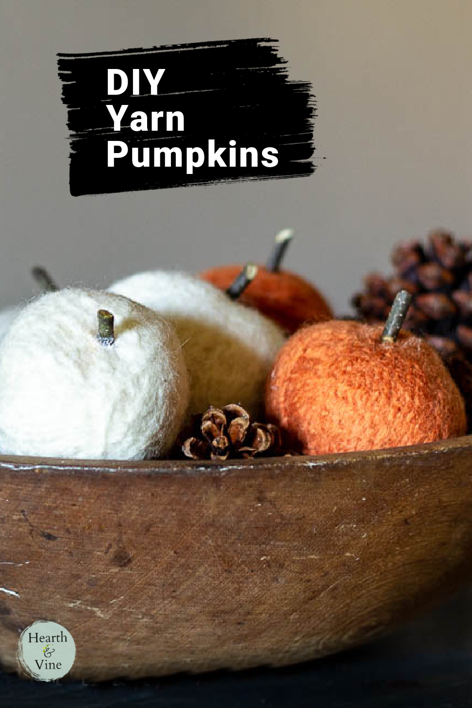 Dough bowl filled with felted yarn pumpkins and pine cones for fall decor.