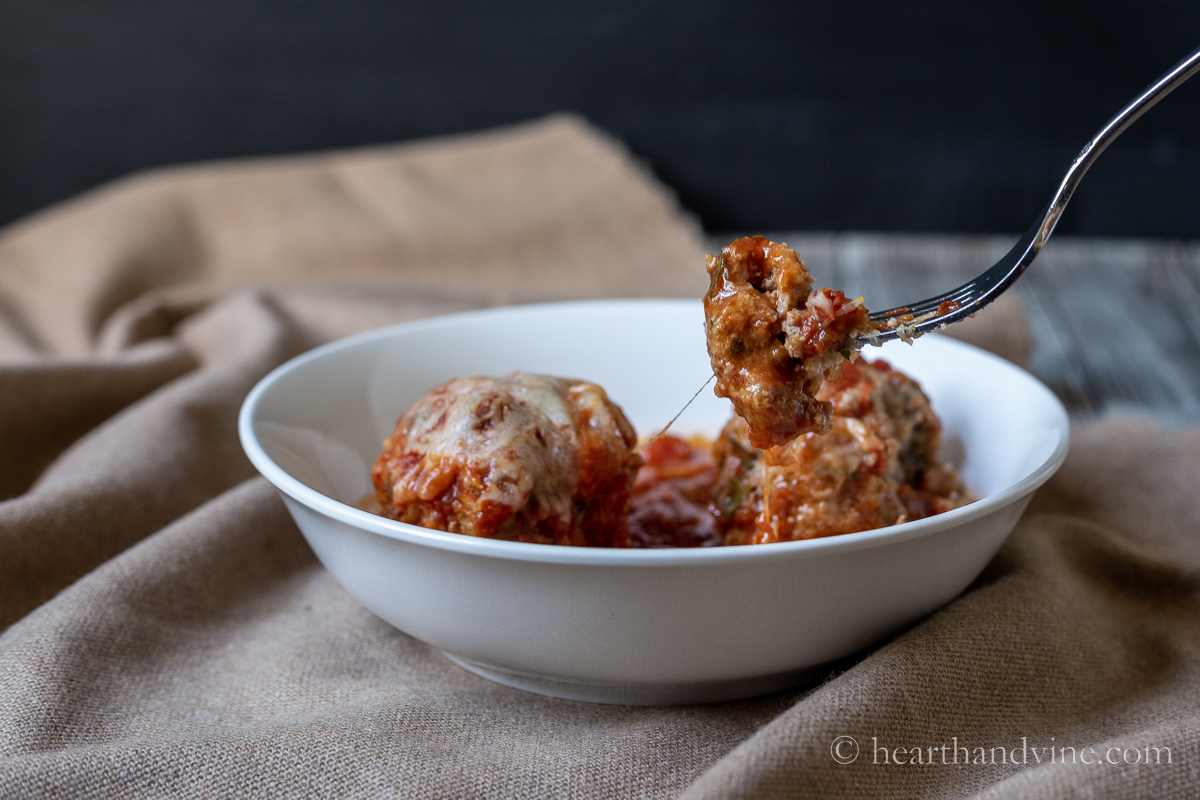 Italian meatball casserole serving with a fork lifting a bite.