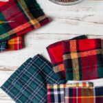 Three sets of plaid hand warmers, fabric and a bowl of flaxseed