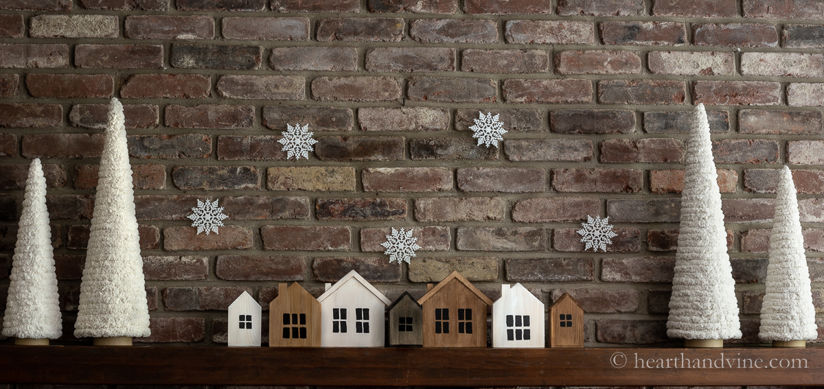 Wooden village and yarn trees on mantel