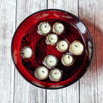 Red bowl with acorn cap candles floating in water
