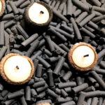 Acorn cap candles on a plate of charcoal pellets