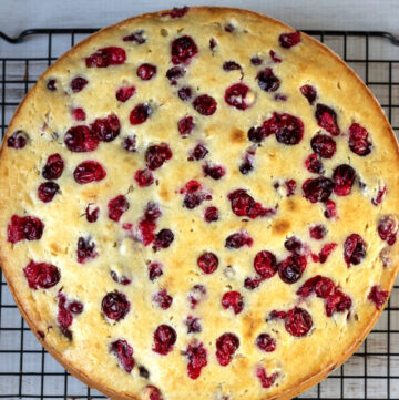 Cranberry ricotta cake on a cooling rack.