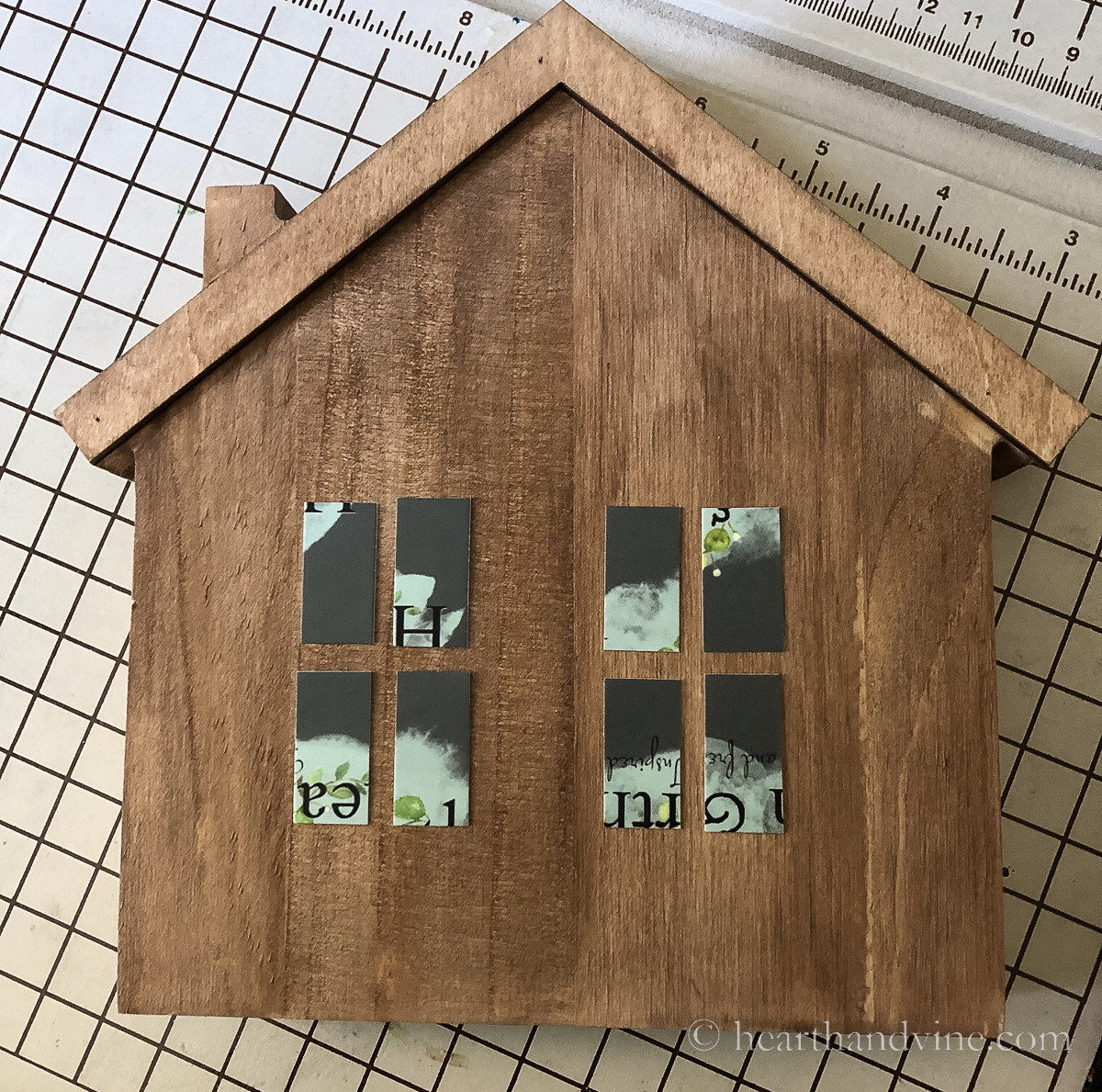 Stained wood house with cut up paper for windows glued on as a template.
