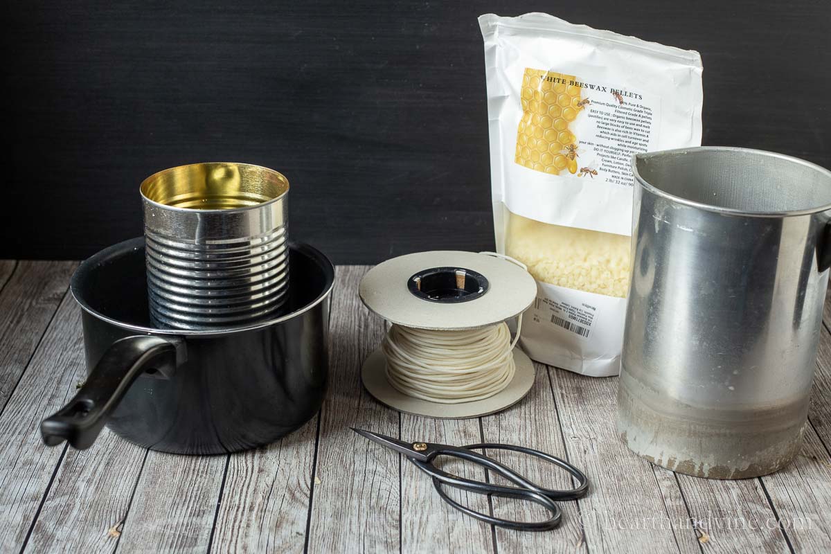 Pot with tall can, spool of wicking, scissors, bag of beeswax pellets and a candle pitcher.