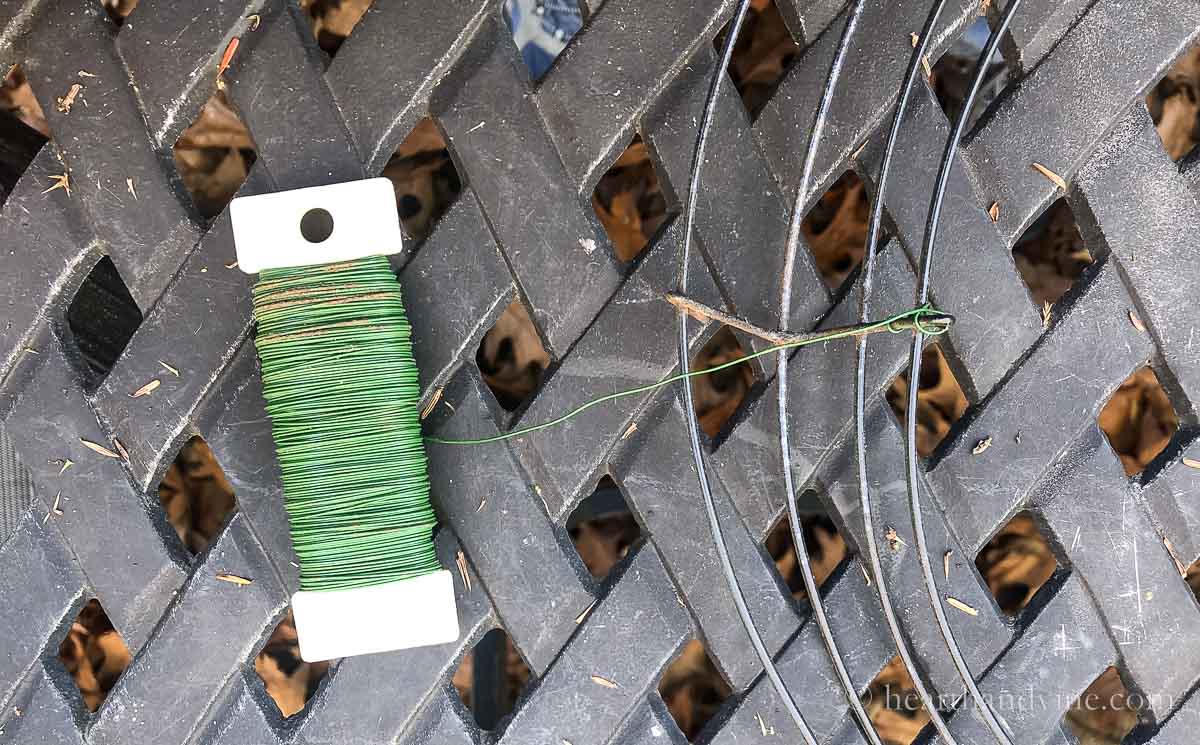 A florist wire paddle attached to the cross section of a wire wreath frame.