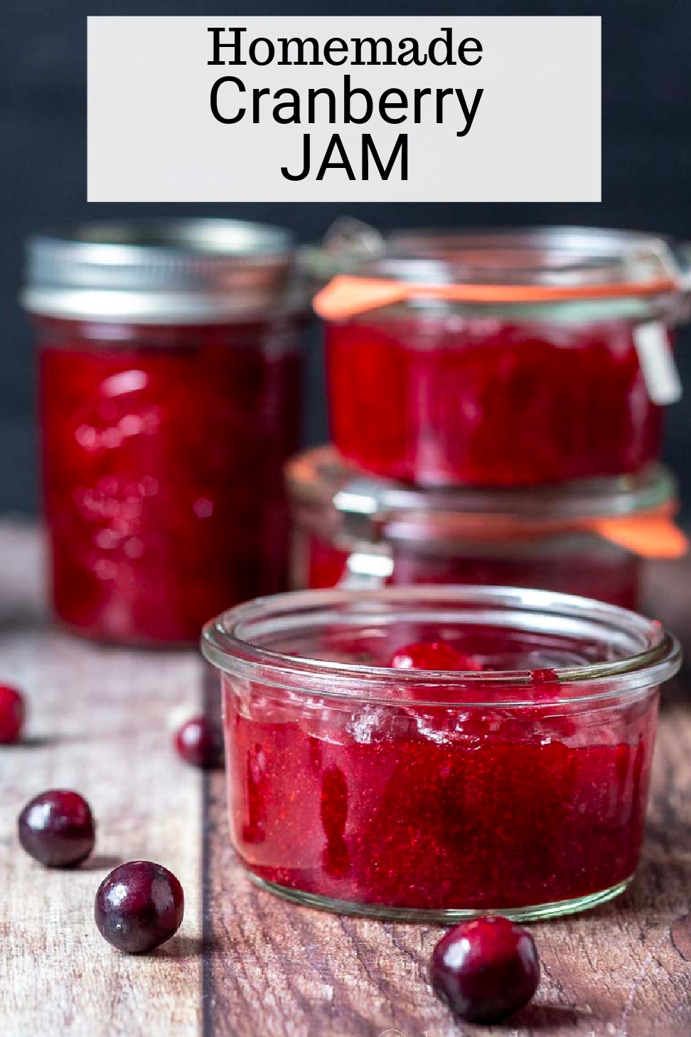 Close up look at a mini jar of cranberry jam with more jars in the background.