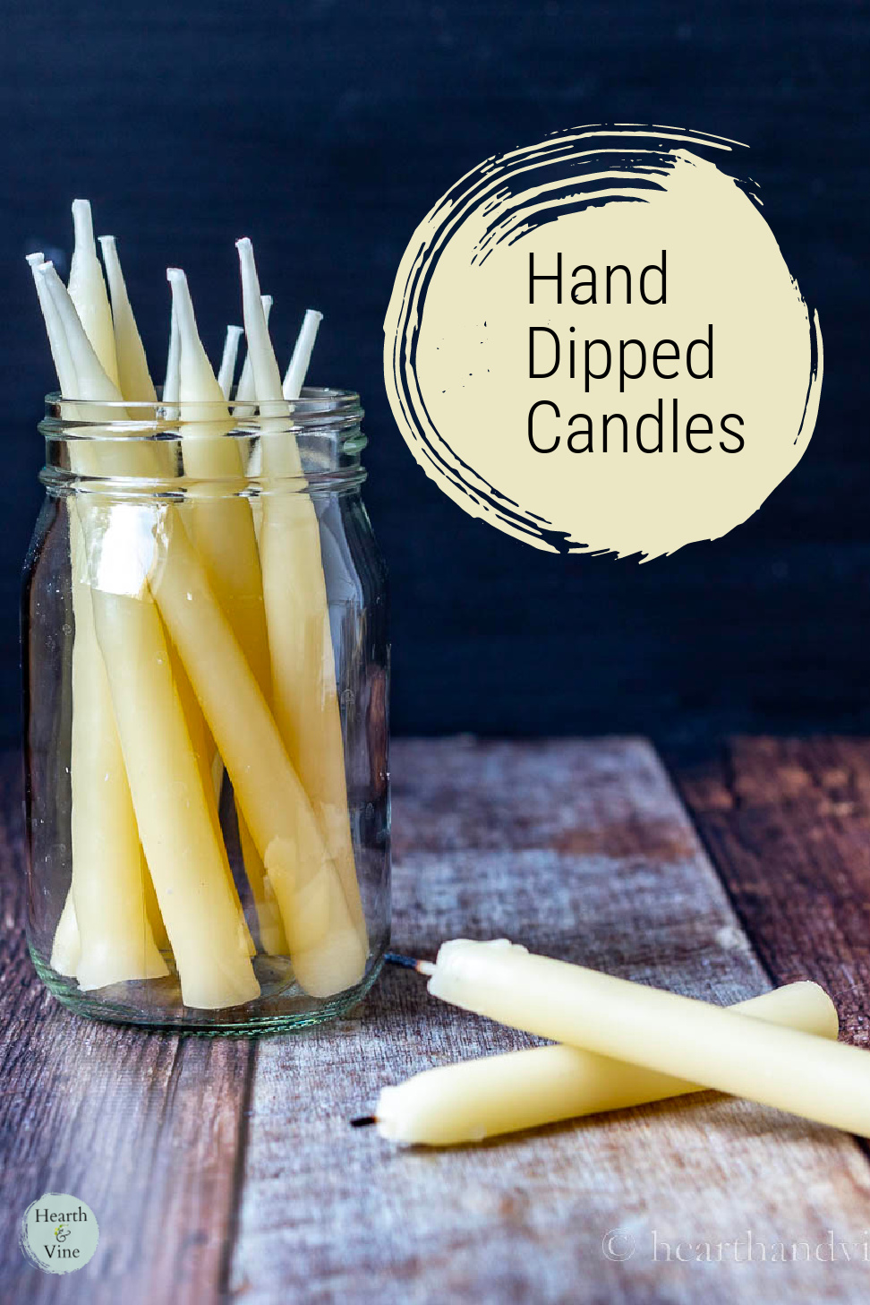 A jar of hand dipped beeswax candles and two on the table.