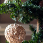 Twine ball glitter ornament on a Christmas tree.