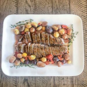 Platter with pork tenderloin, potatoes and tomatoes.