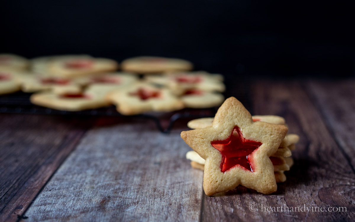 Stack of stained glass star cookies with one standing up leaning on the stack.