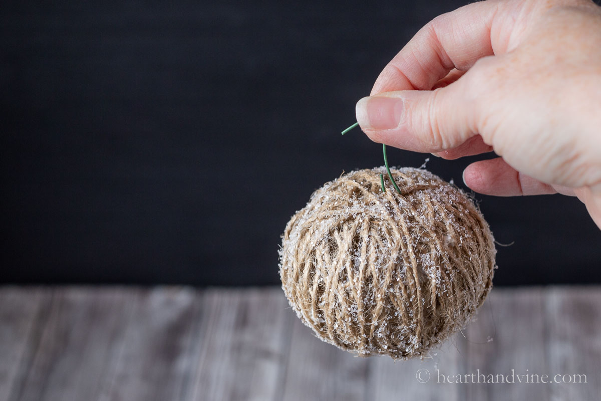 One glittered twine ball with an ornament hanger.