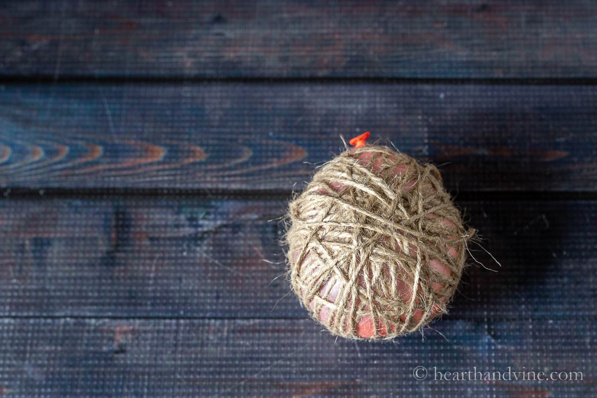 A small orange balloon wrapped in twine.