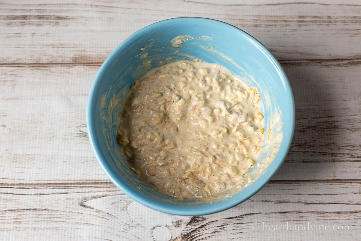 Bowl with ingredients including, corn, cream cheese, shredded cheese, mayo and spices.