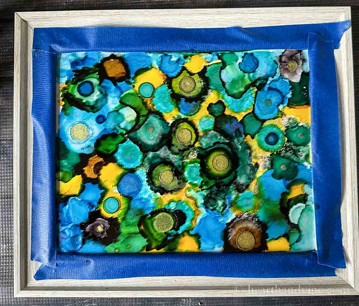 Finished alcohol ink on glass painting with tape still on.