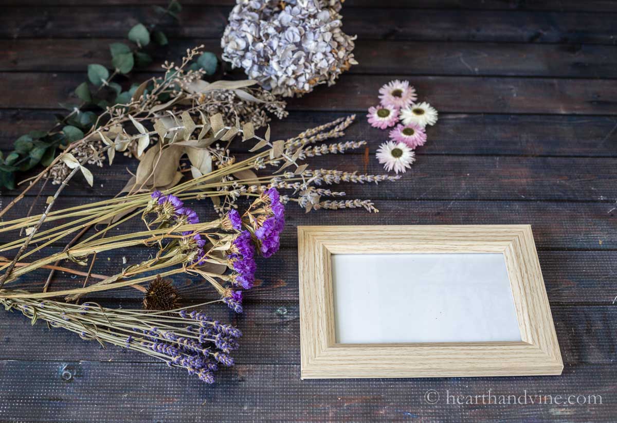Small photo frame next to a group of dried flowers.