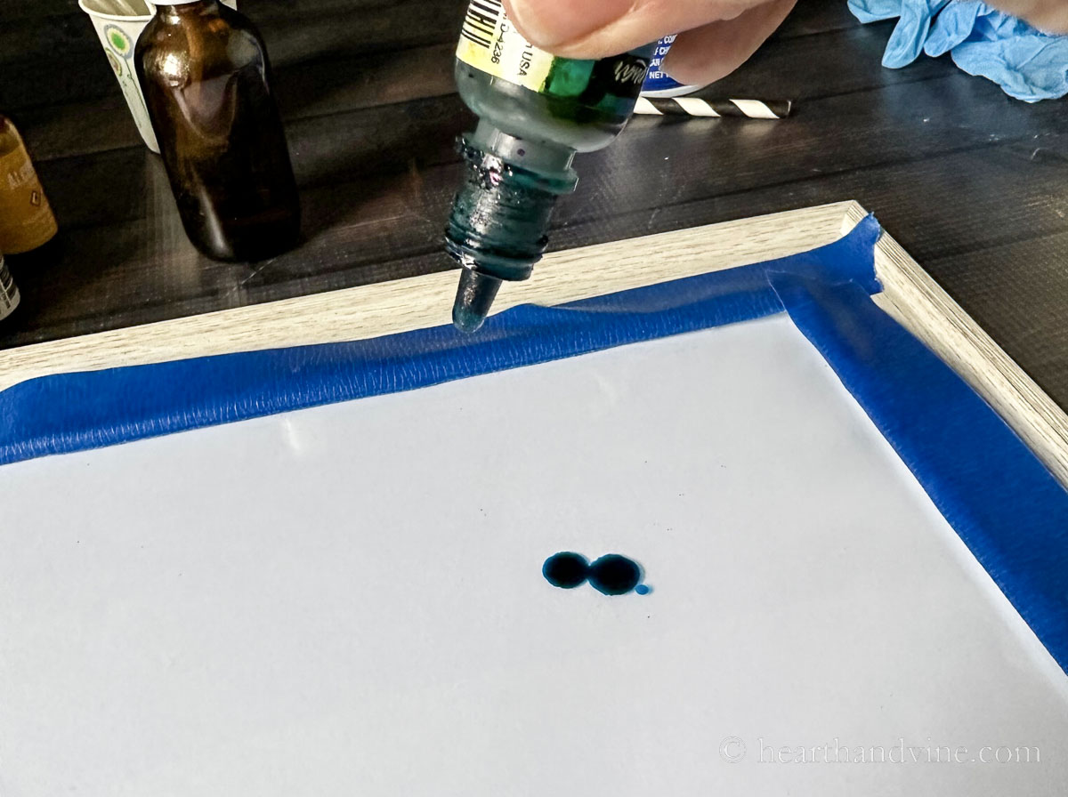 Drops of blue alcohol ink on glass.