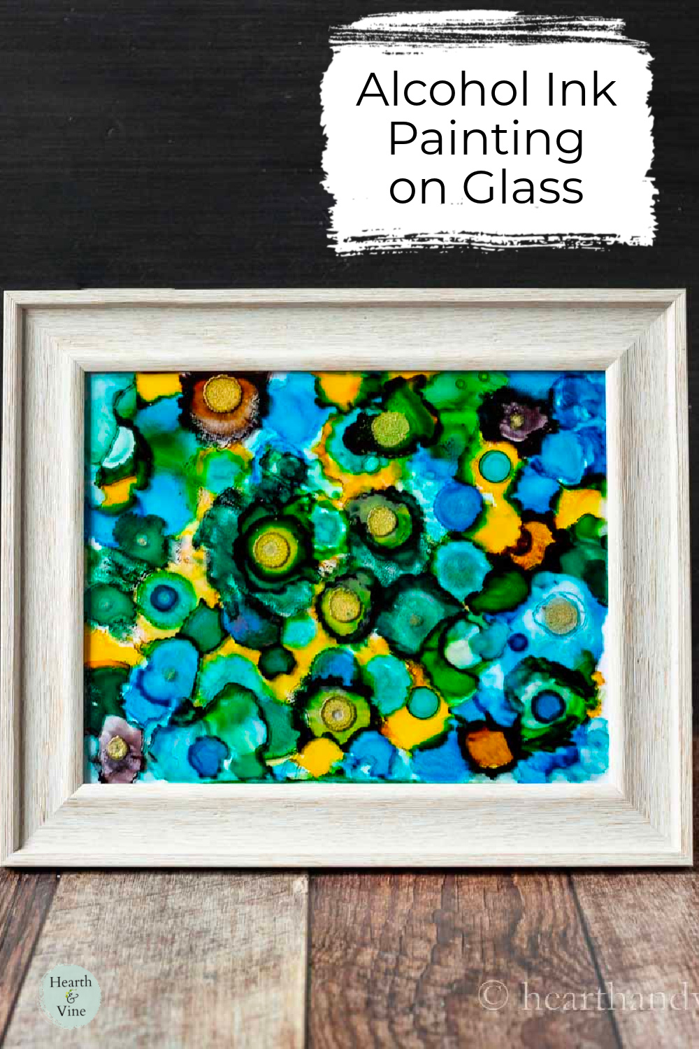 A white framed alcohol ink on glass painting.