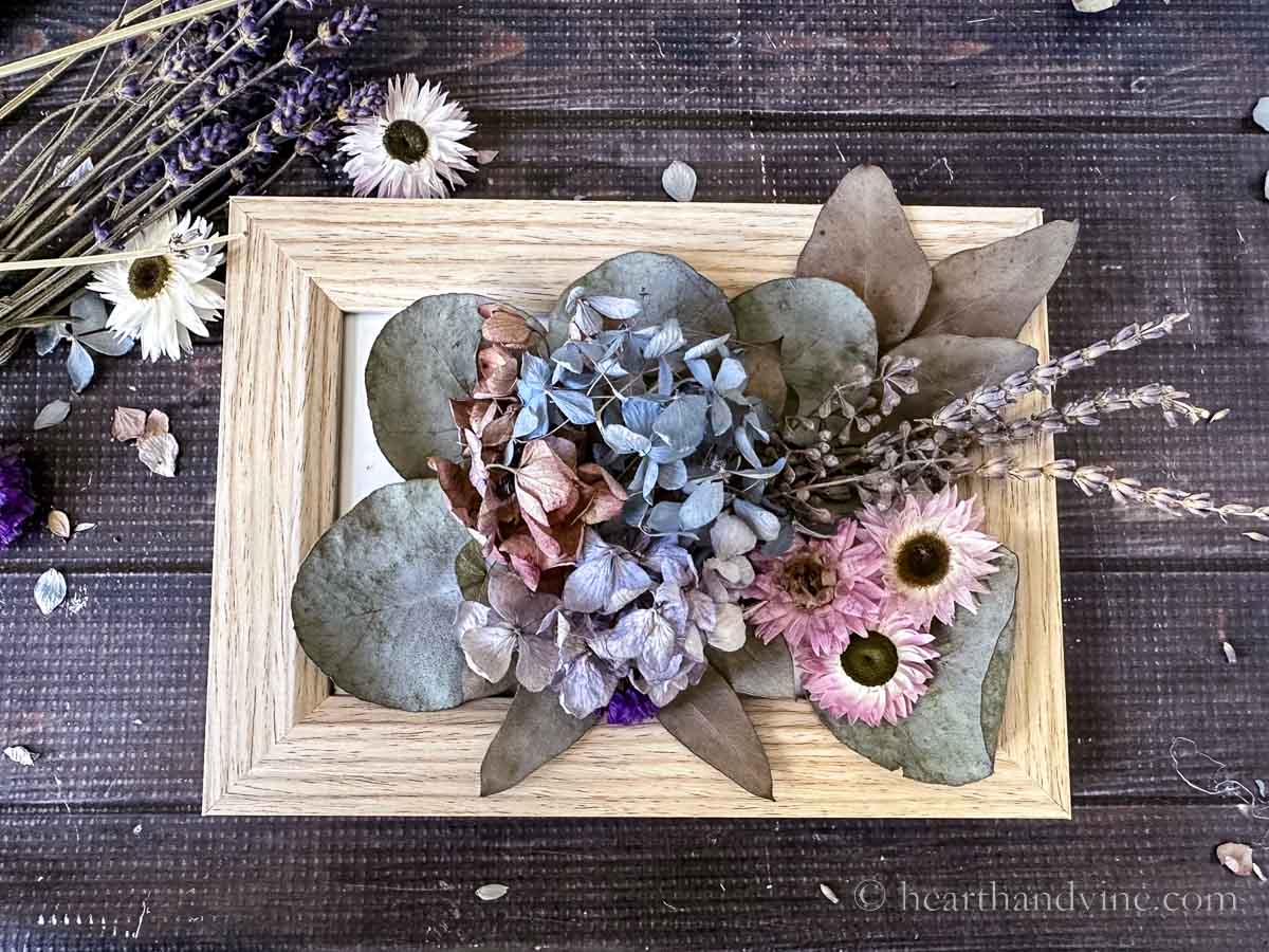 Dried flowers and leaves glued to the glass on a photo frame.