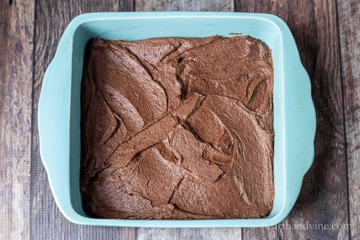 Brownie batter spread into an 8 x 8 inch baking pan.