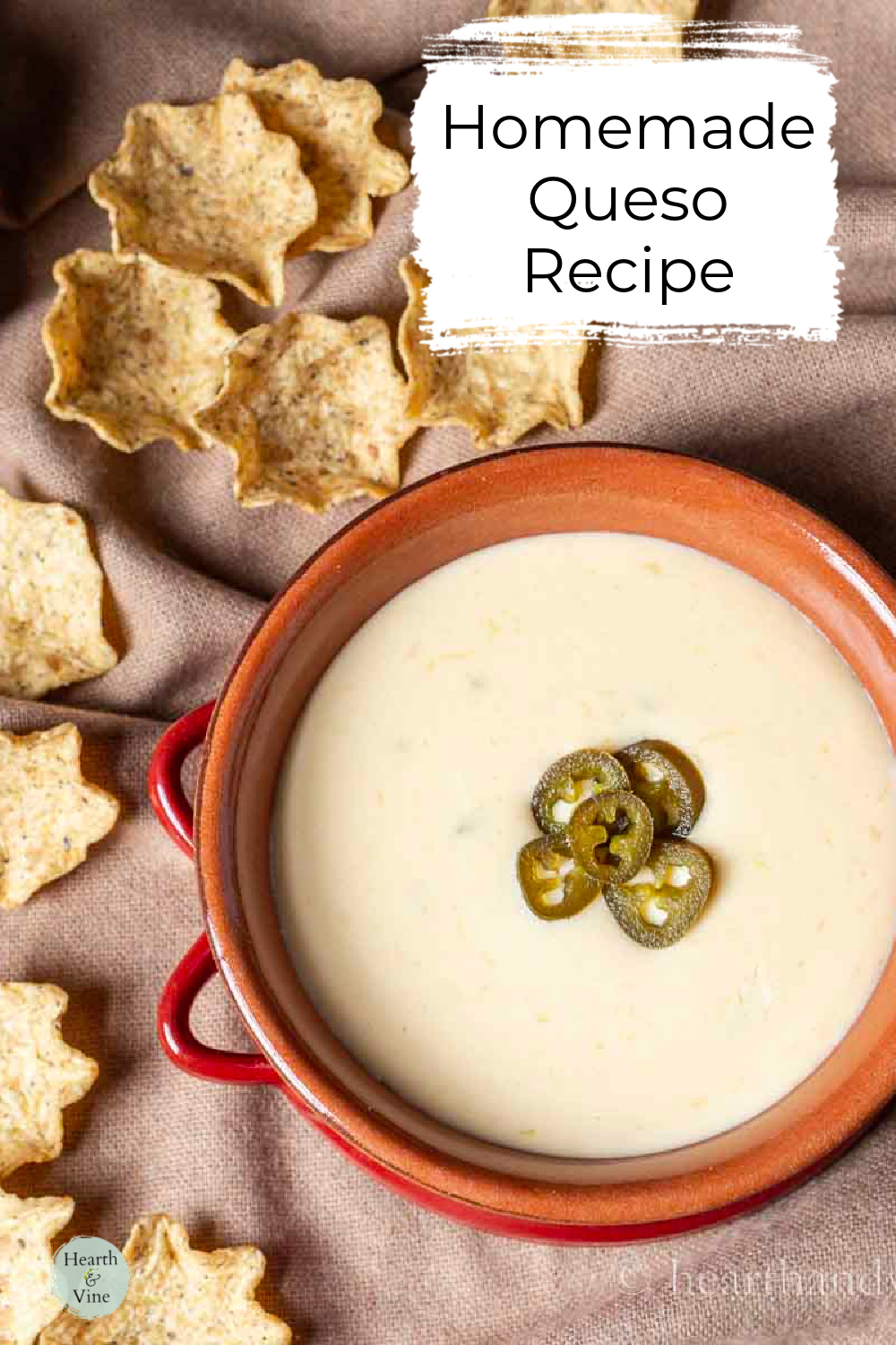 Bowl of white queso with slices of jalapeno in the middle and tortilla chips on the side.