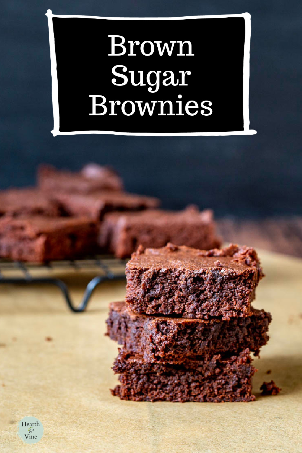 Three brown sugar browns stacked in front of a cooling rack of the same brownies.