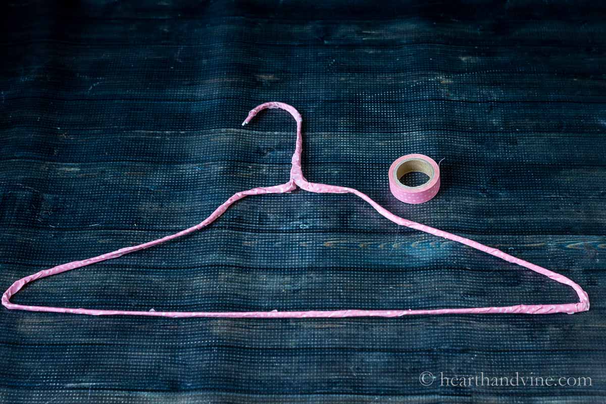 Two wire hangers wrapped with pink washi tape.