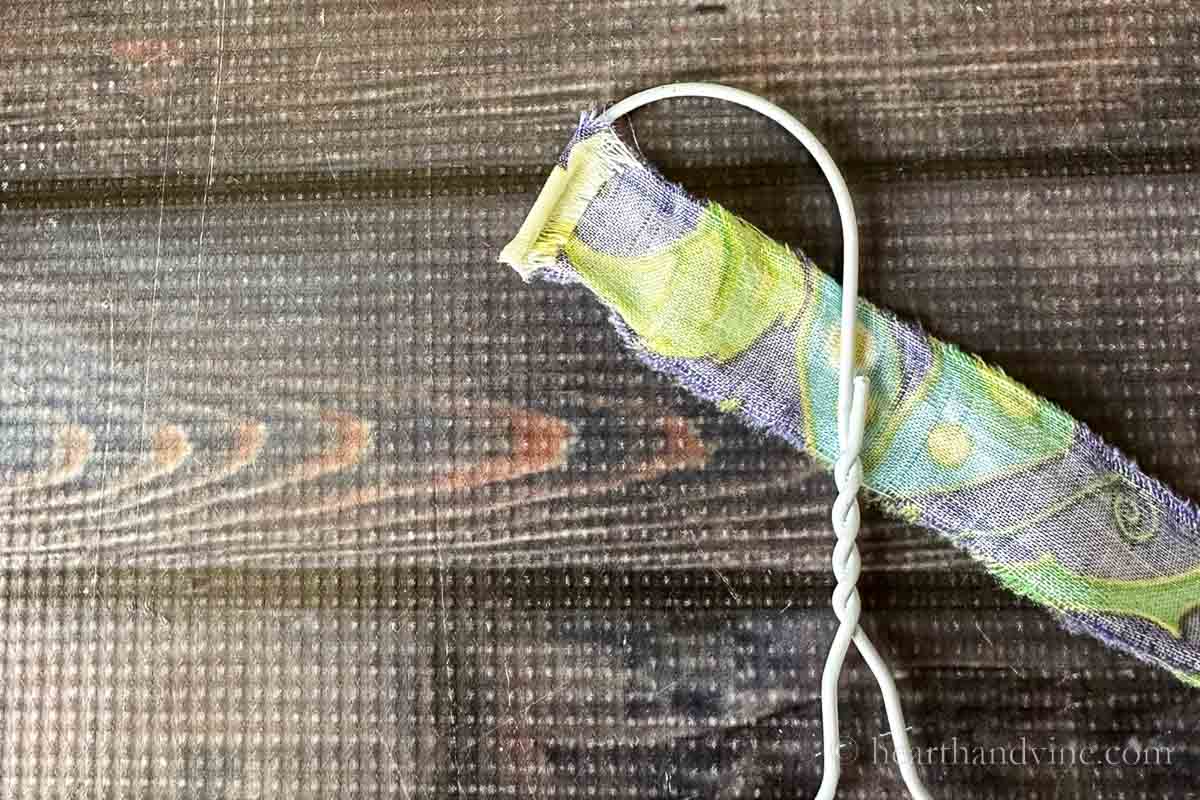 A strip of fabric wrapped around the tip of a coat hanger.