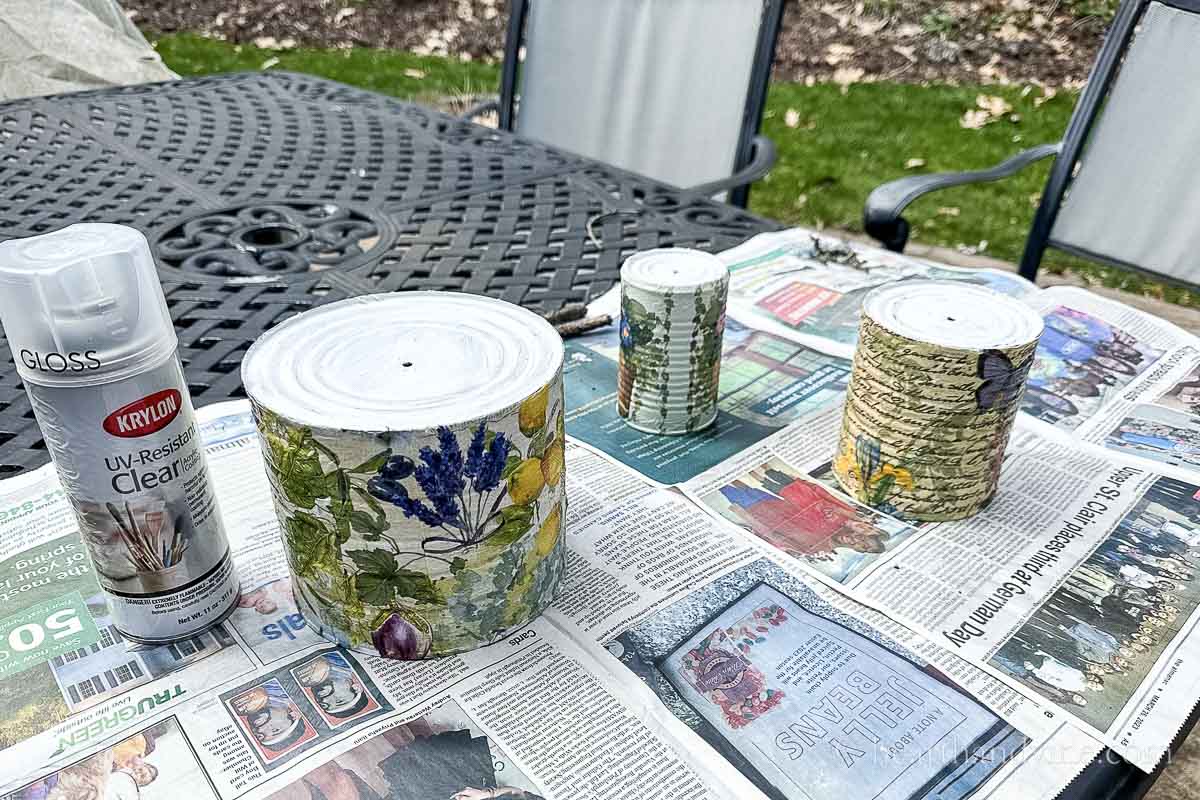 Protective polyurethane is sprayed outdoors on the cans.