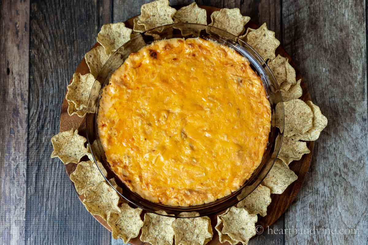 Baked buffalo chicken dip without cream cheese surrounded by tortilla scoops.