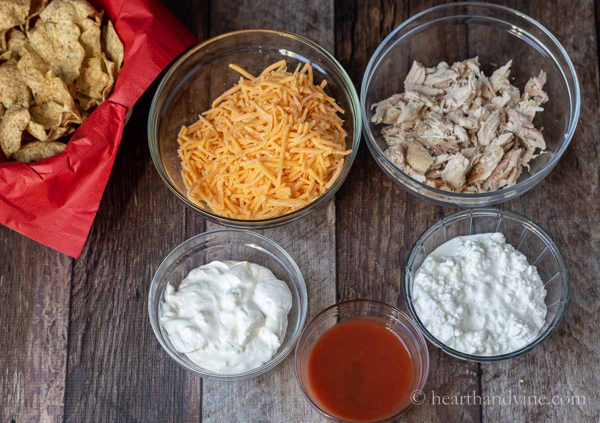 Ingredients including shredded cheddar cheese, cottage cheese, sour cream, shredded chicken, and hot sauce.