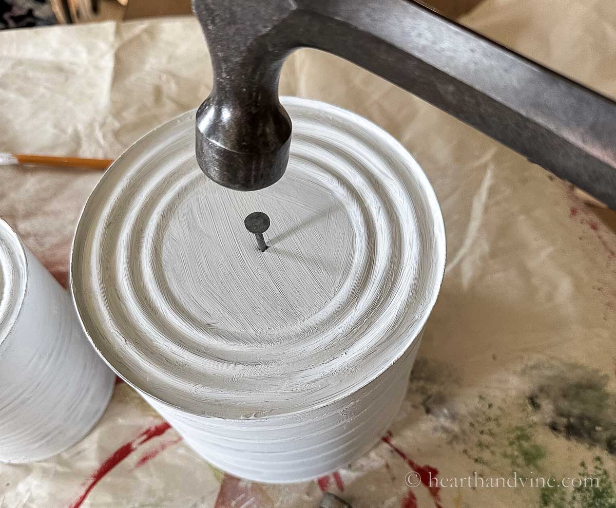 Hammering a large nail in the lid of a can.