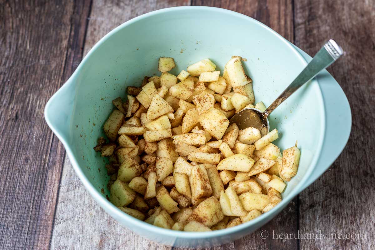 Bowl of chopped apples with brown sugar and cinnamon.