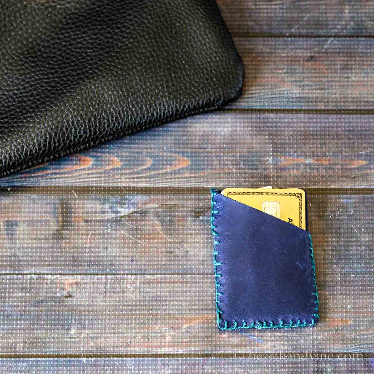 Leather card holder next to a small black purse.