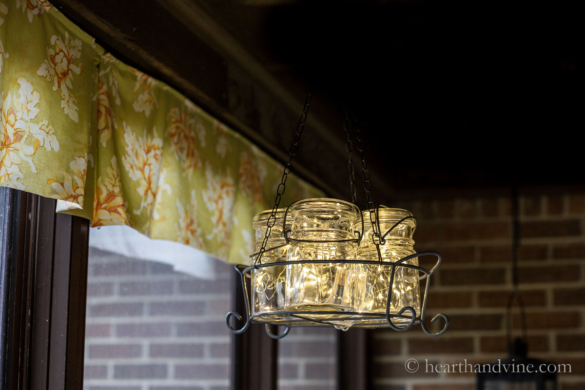Hanging mason jar chandelier on screened in porch.