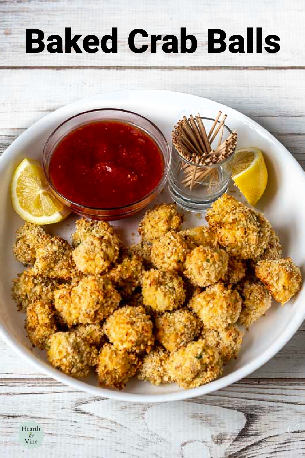 Bowl of crab balls with lemon wedges, toothpicks, and cocktail sauce on the side.