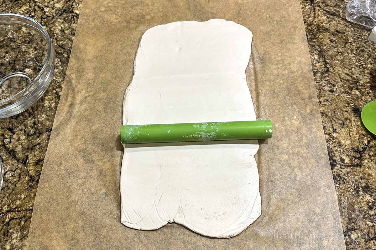 Air dry clay rolled out on parchment paper.