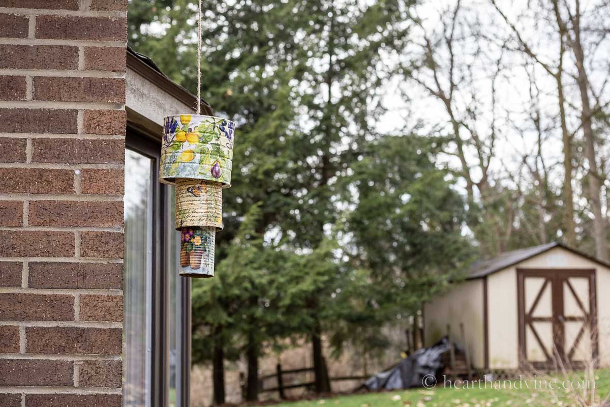 DIY wind chimes with cans hanging outside.