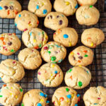 A wire cooling rack with baked peanut butter cookies with mini m&ms.