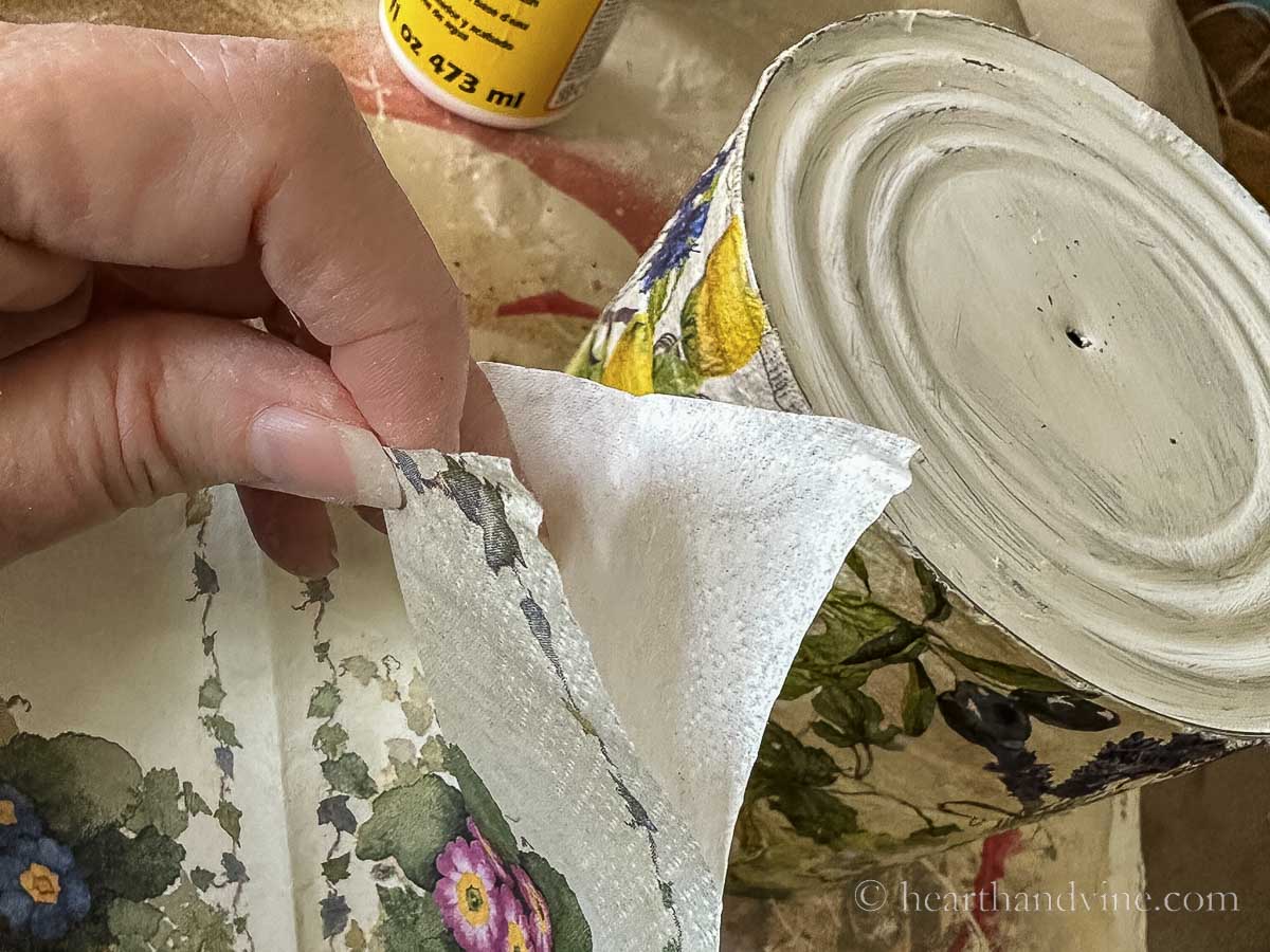 Pulling the backing paper of a floral napkin off.