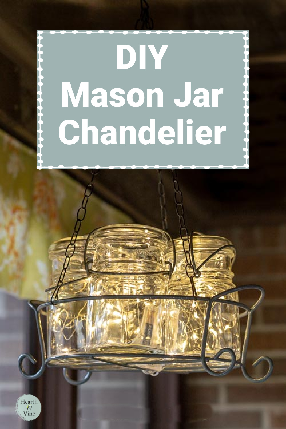 Group of mason jars in a wire caddy hanging with fairy lights inside to create a rustic chandelier.