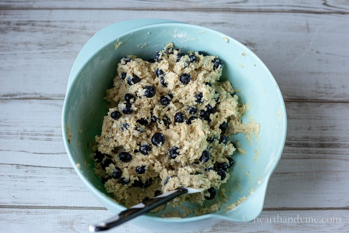 Raw blueberry cookie dough in a mixing bowl with a rubber spatula.