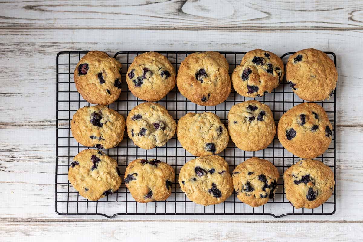 Freshly baked blueberry cookies on a cooling rack.