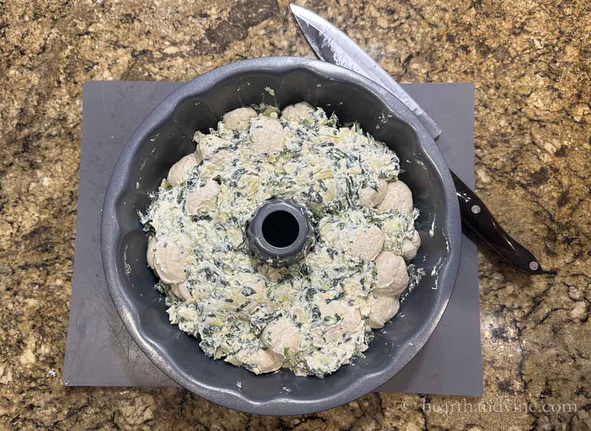 Final layer of spinach mixture and biscuit balls.