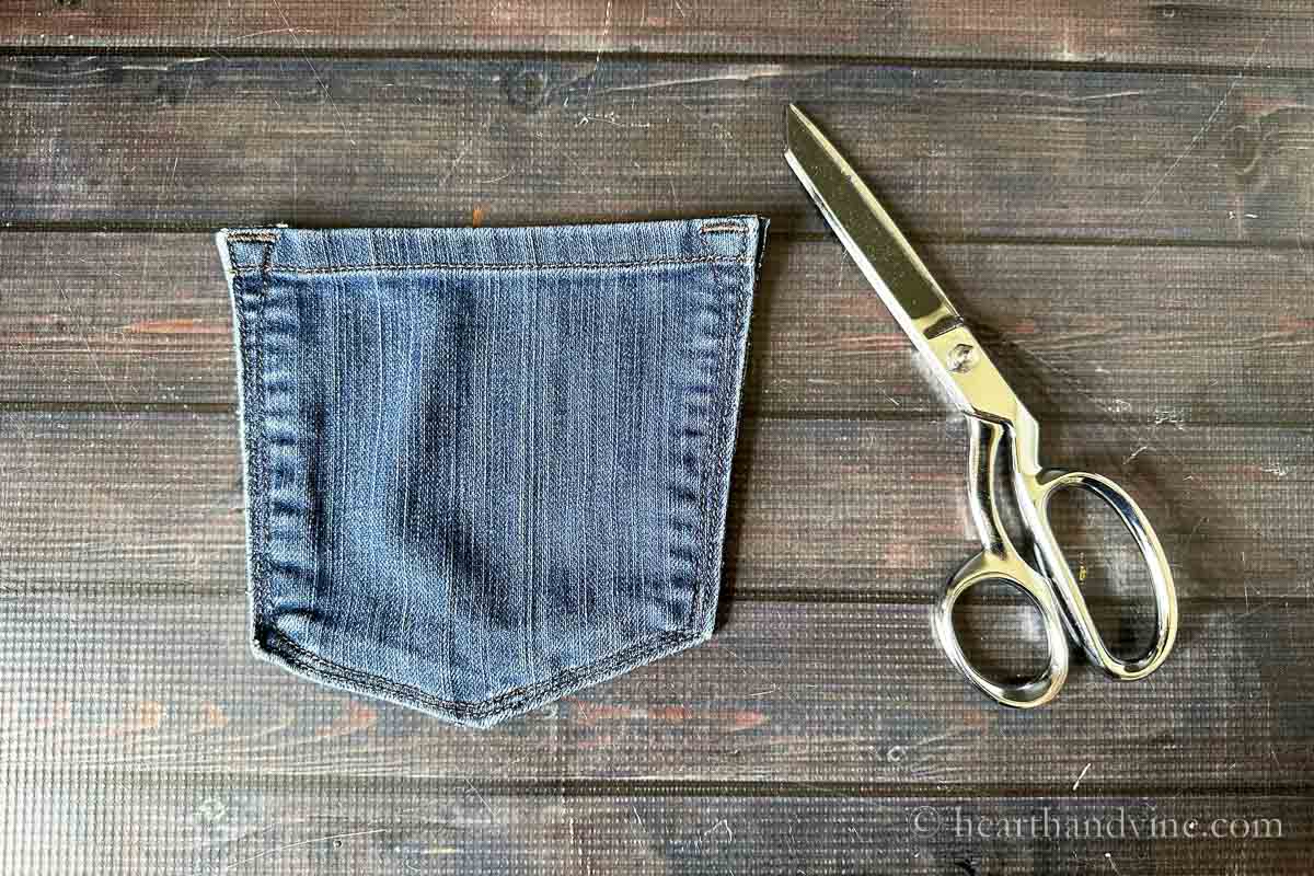 A cut out pocket from jeans and a pair of sewing scissors.