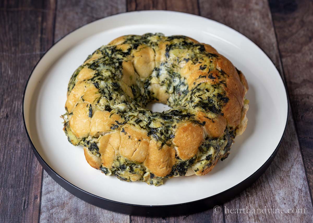 Spinach artichoke pull apart bread on a serving tray.