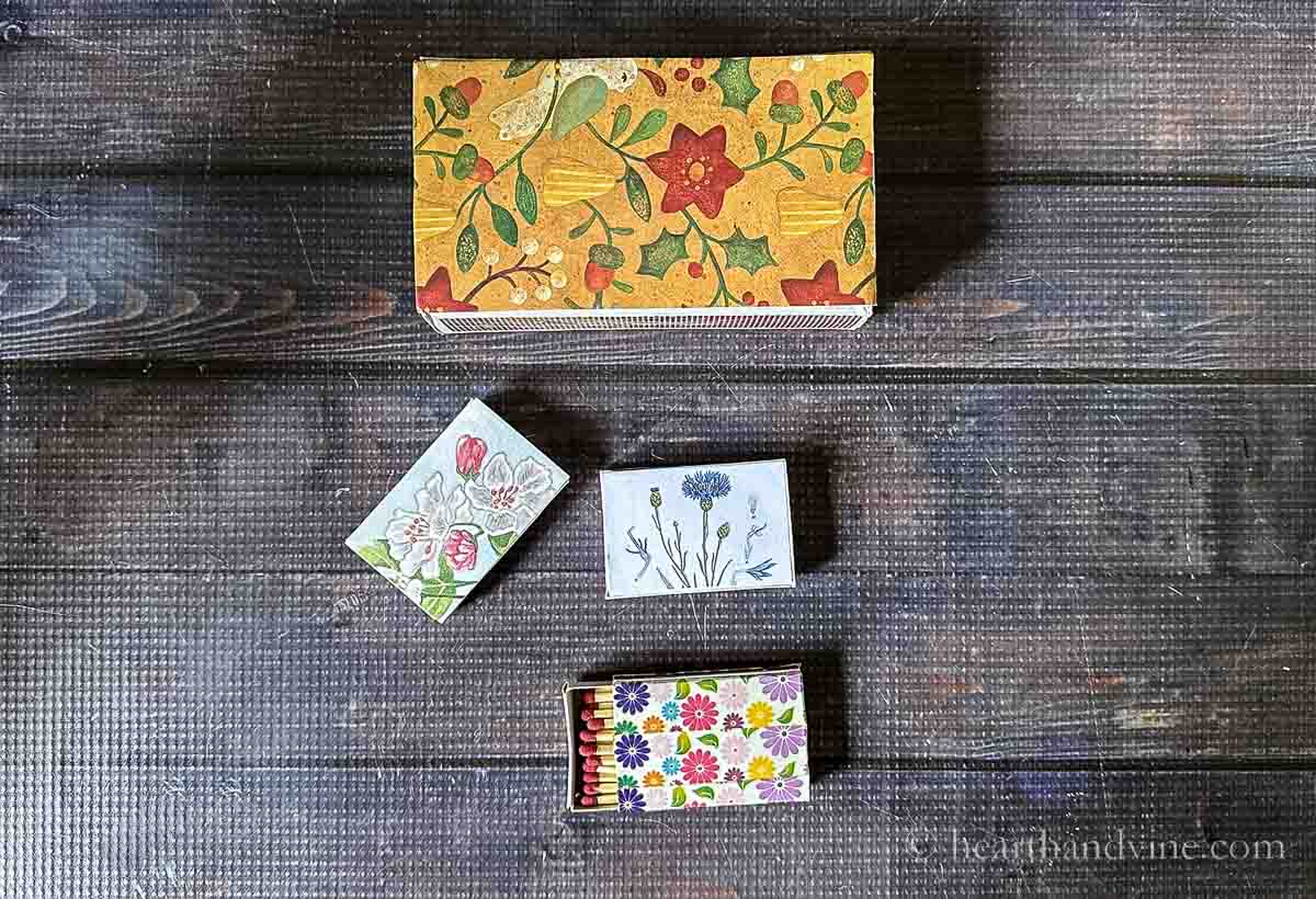 Aerial view of a large decorated matchbox and three small matchboxes decorated in floral styles.